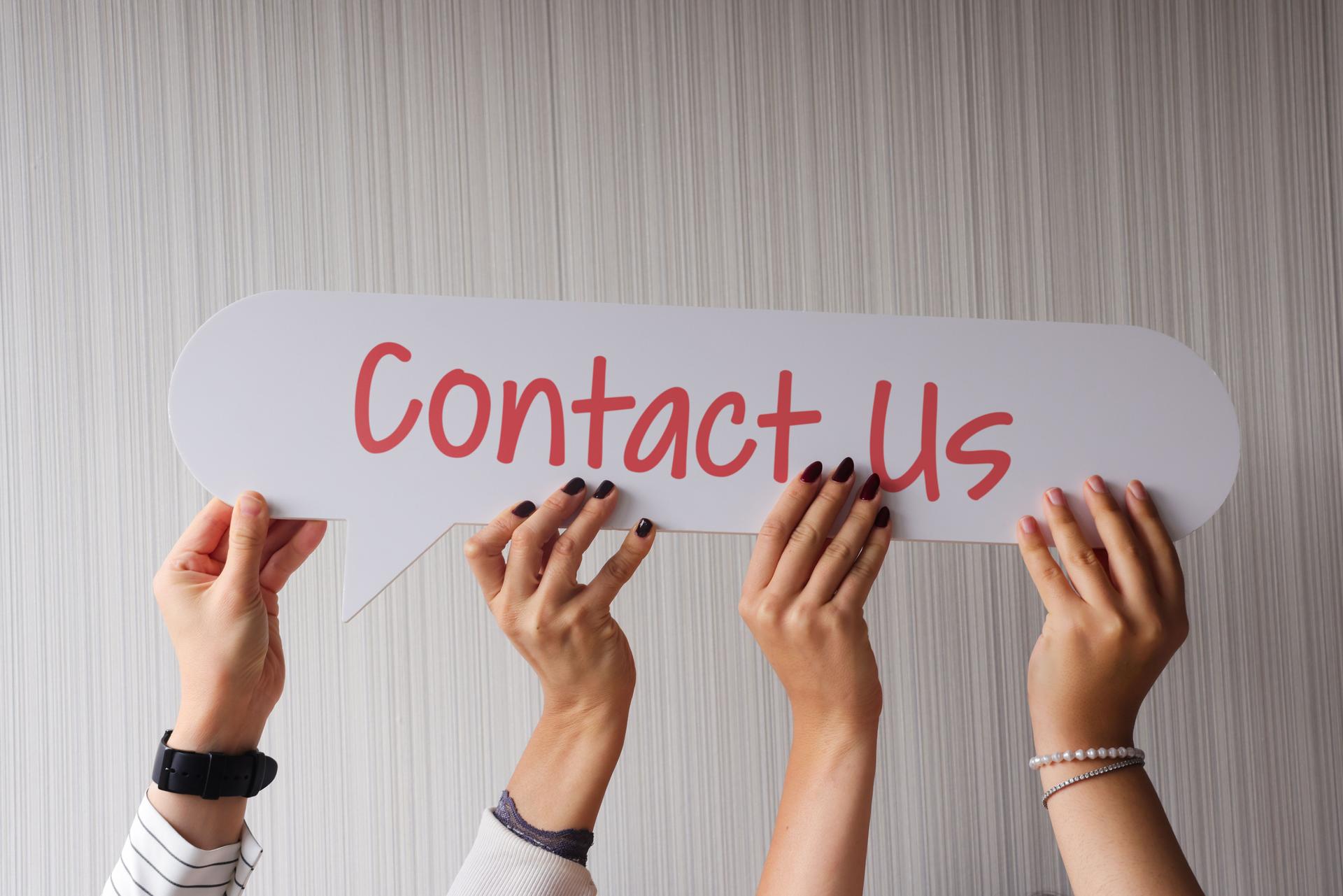 Hand holding speech bubble with Contact Us message